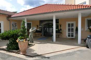 Ein Auto ist vor einem Eingangsbereich mit Säulen geparkt