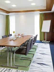 Ein kleiner Konferenzraum mit acht St&uuml;hlen und einer Leinwand