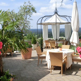 Die mit Blumen geschmückte Terrasse des Distlerhofs bietet Plätze zum Essen in der Sonne mit Blick über das Nürnberger Land